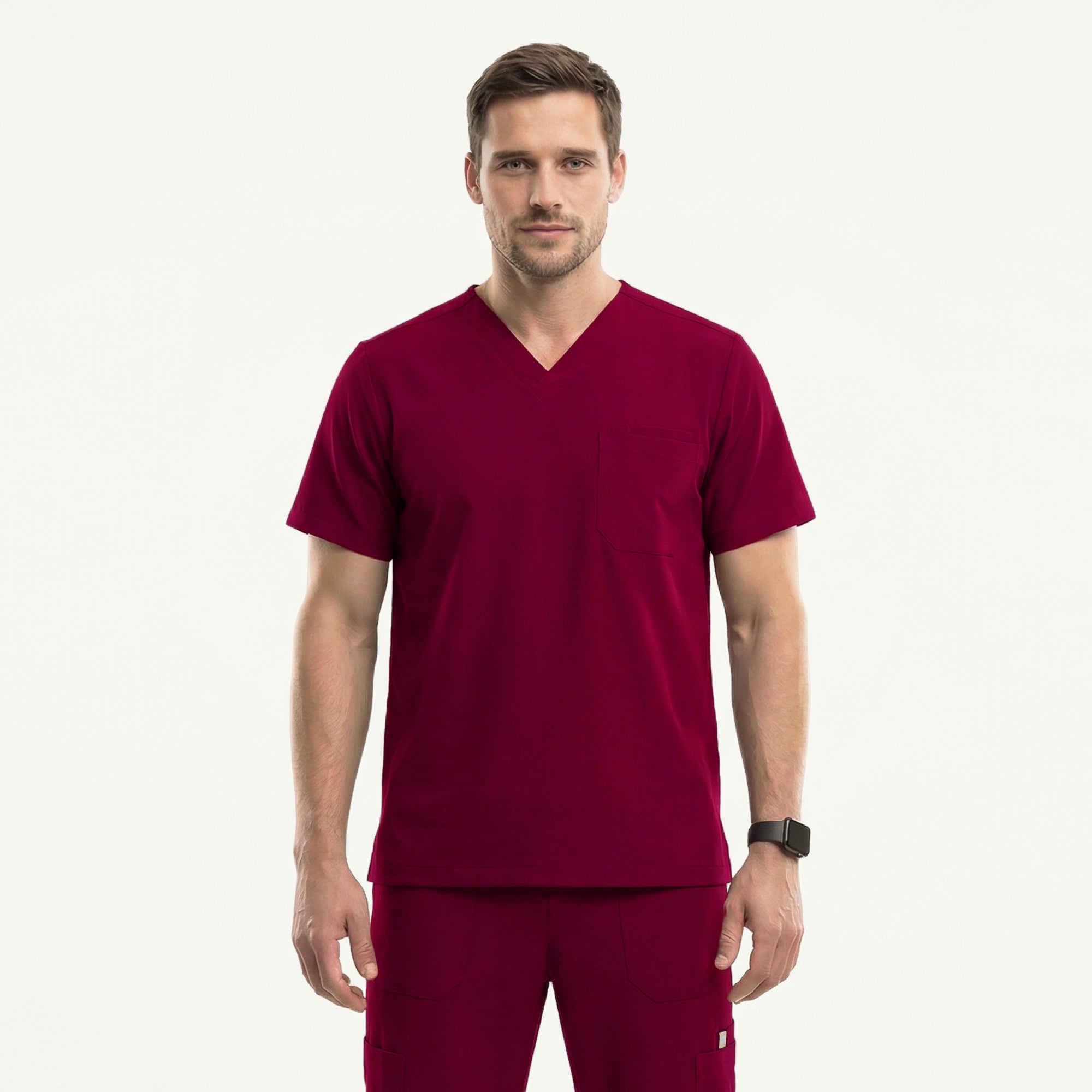 Image of Man in a burgundy V-neck scrub top with badge holder and front pocket, paired with matching scrub pants, hands in pockets,Burgundy