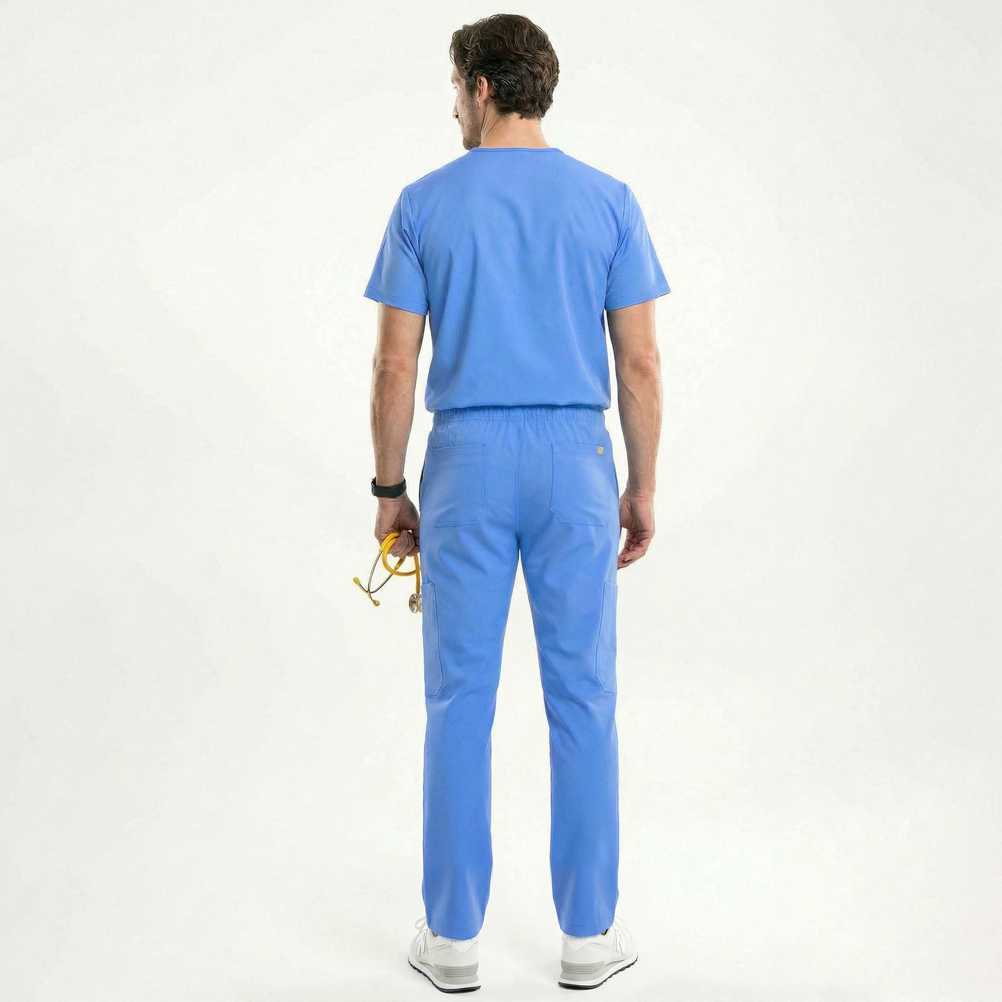 Image of Male model in a ceil blue V-neck scrub set featuring straight-leg pants with functional pockets, holding a yellow stethoscope and wearing white sneakers,Ceil Blue