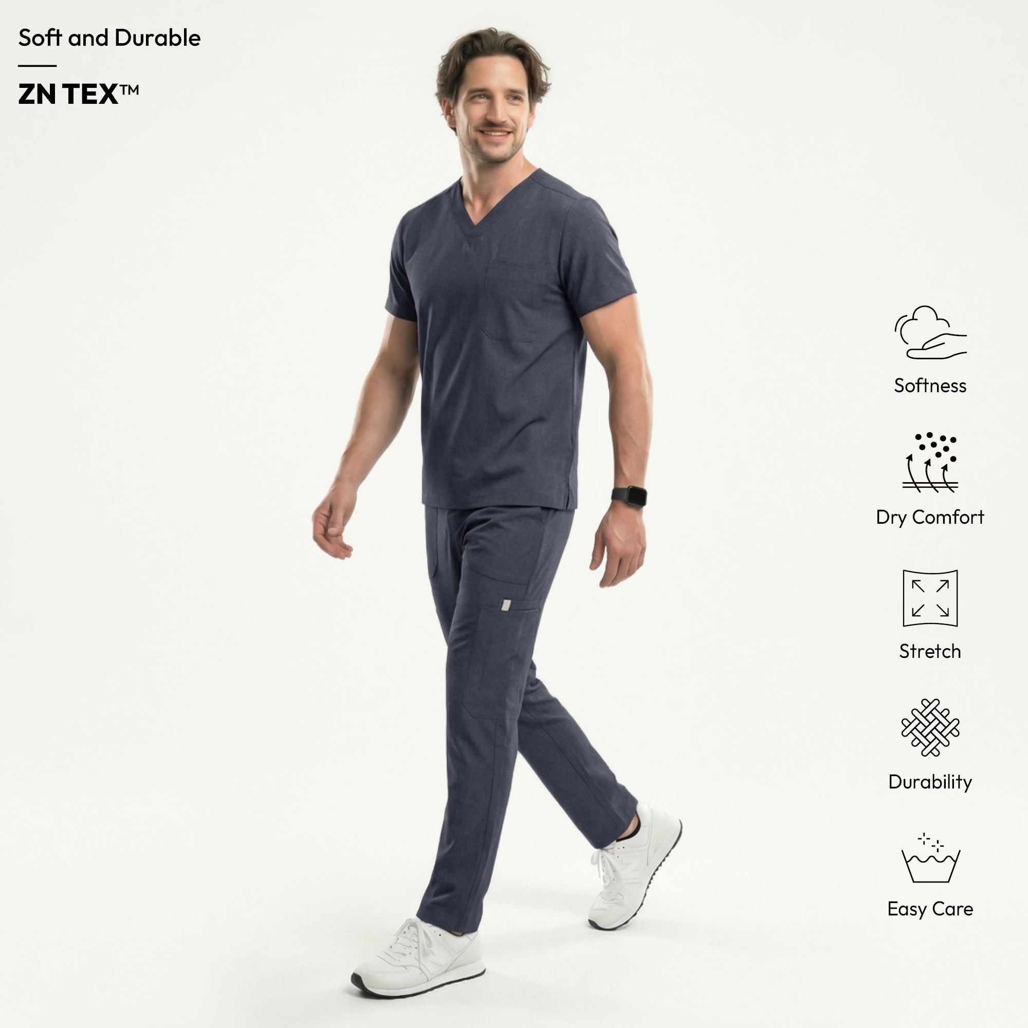 Image of Male healthcare professional wearing a charcoal gray V-neck scrub top and matching jogger pants, with one hand in pocket, standing against a plain background,Charcoal-Gray