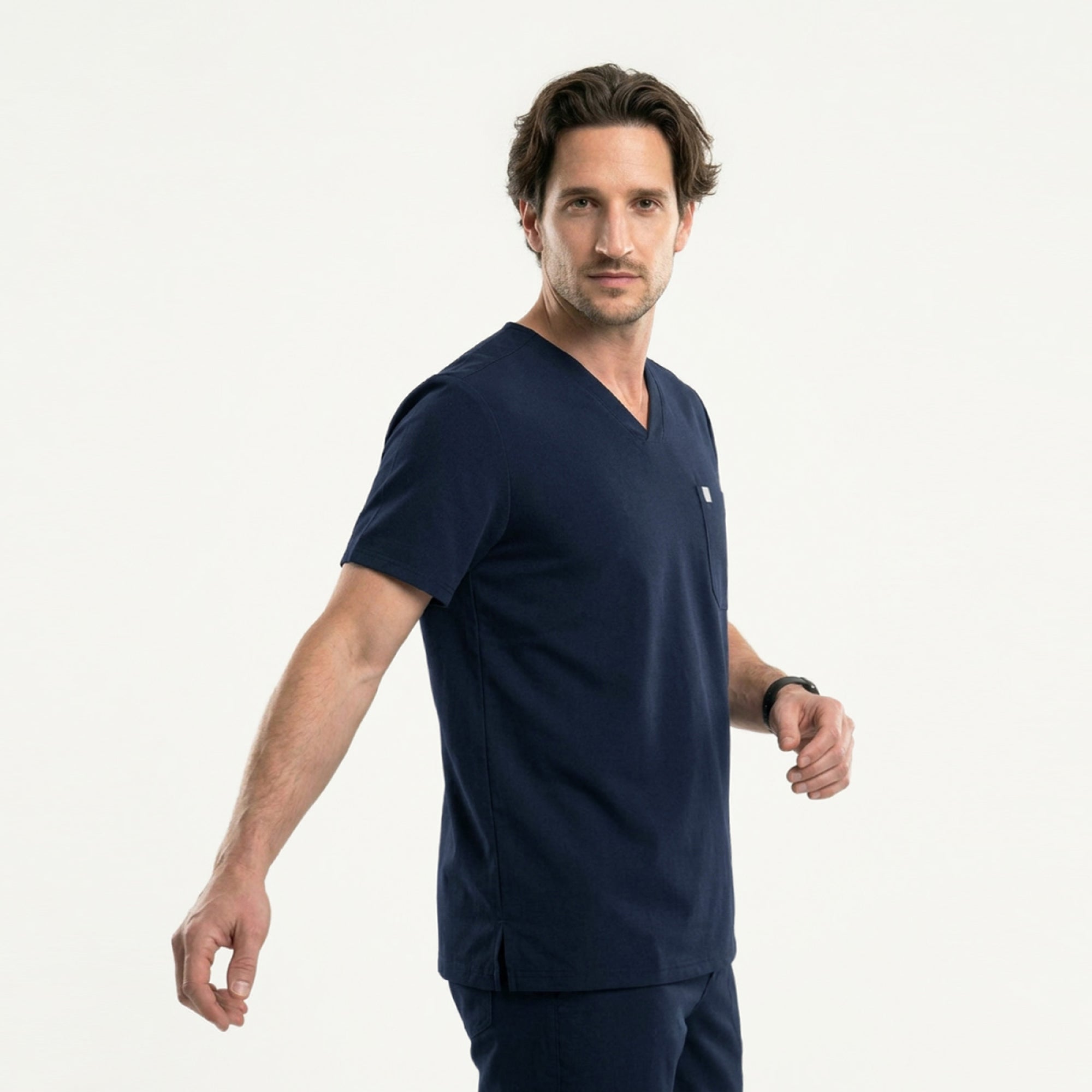 Image of Side profile of a man wearing a navy scrub set with a drawstring waistband and a single-pocket top,Eco Navy