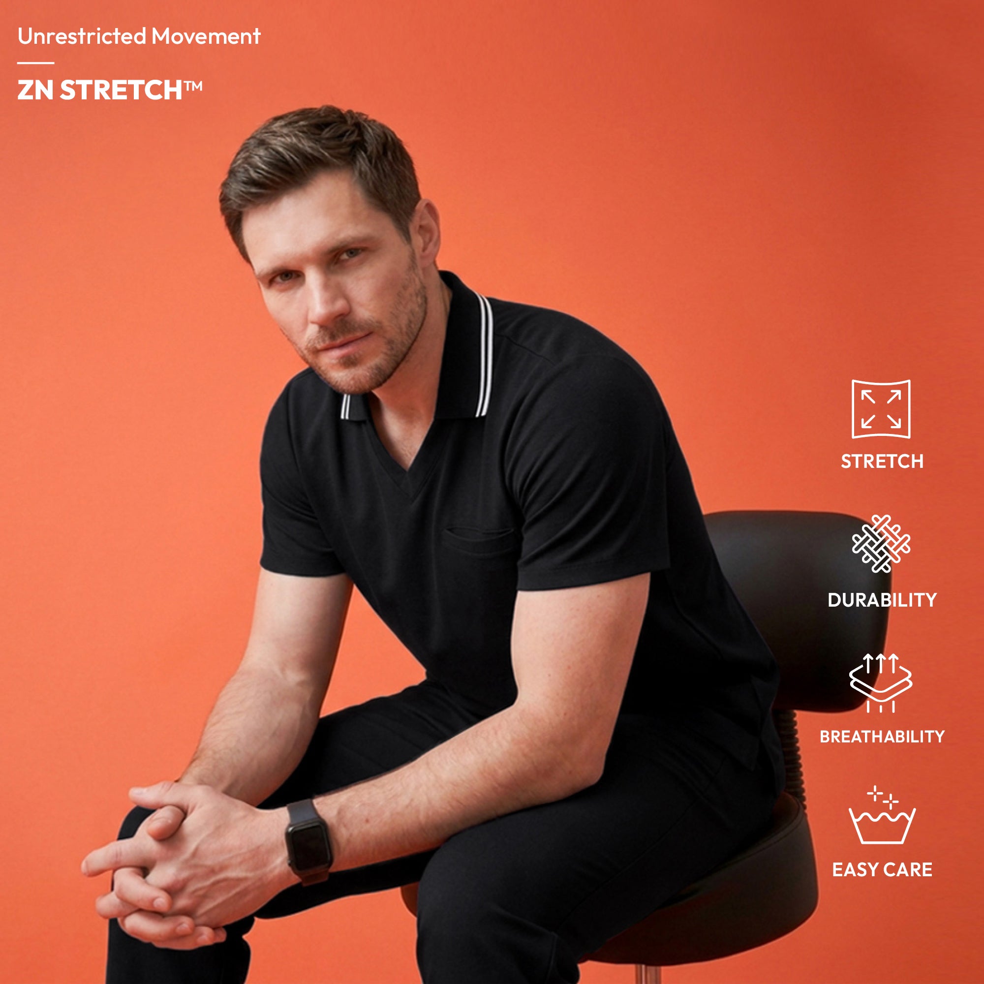 Image of Male model wearing a jet black performance polo scrub top with a striped collar, standing with arms crossed,Jet Black