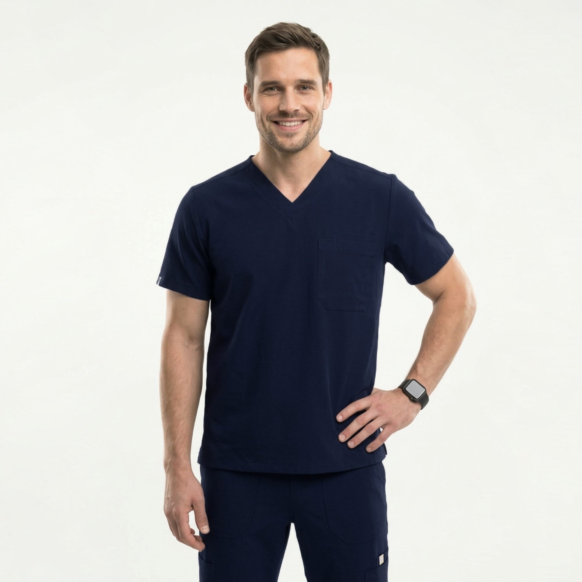 Image of Male healthcare professional wearing a navy V-neck, three-pocket scrub top with stethoscope around neck, standing against a plain background,Navy