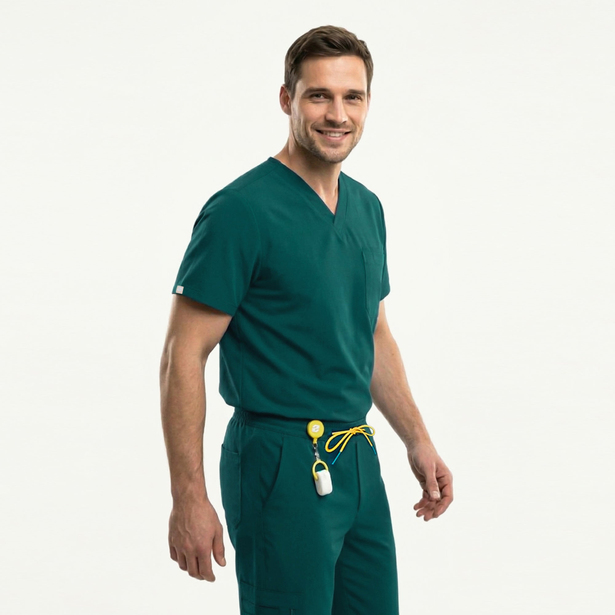 Image of A male model wears the Zenir Pine-Green 3-Pocket Scrub Top with matching pants, showing a clean V-neck design, a functional chest pocket, and a comfortable fit that allows easy movement.