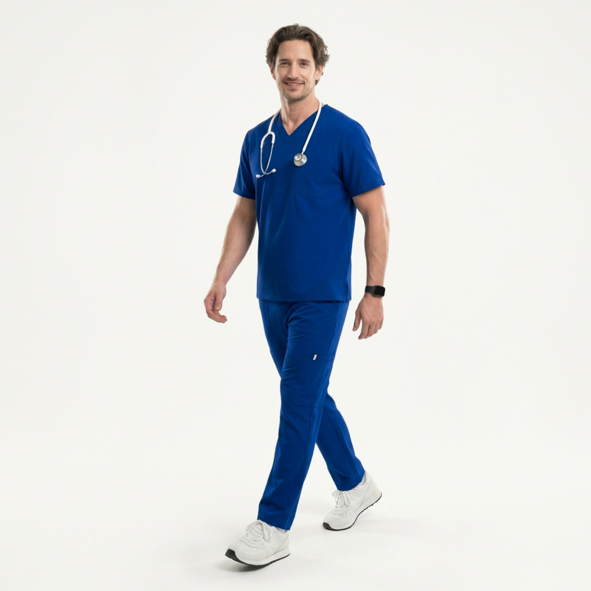 Image of Man wearing a royal blue V-neck scrub top with matching pants, holding a white stethoscope and standing in white sneakers,Royal Blue