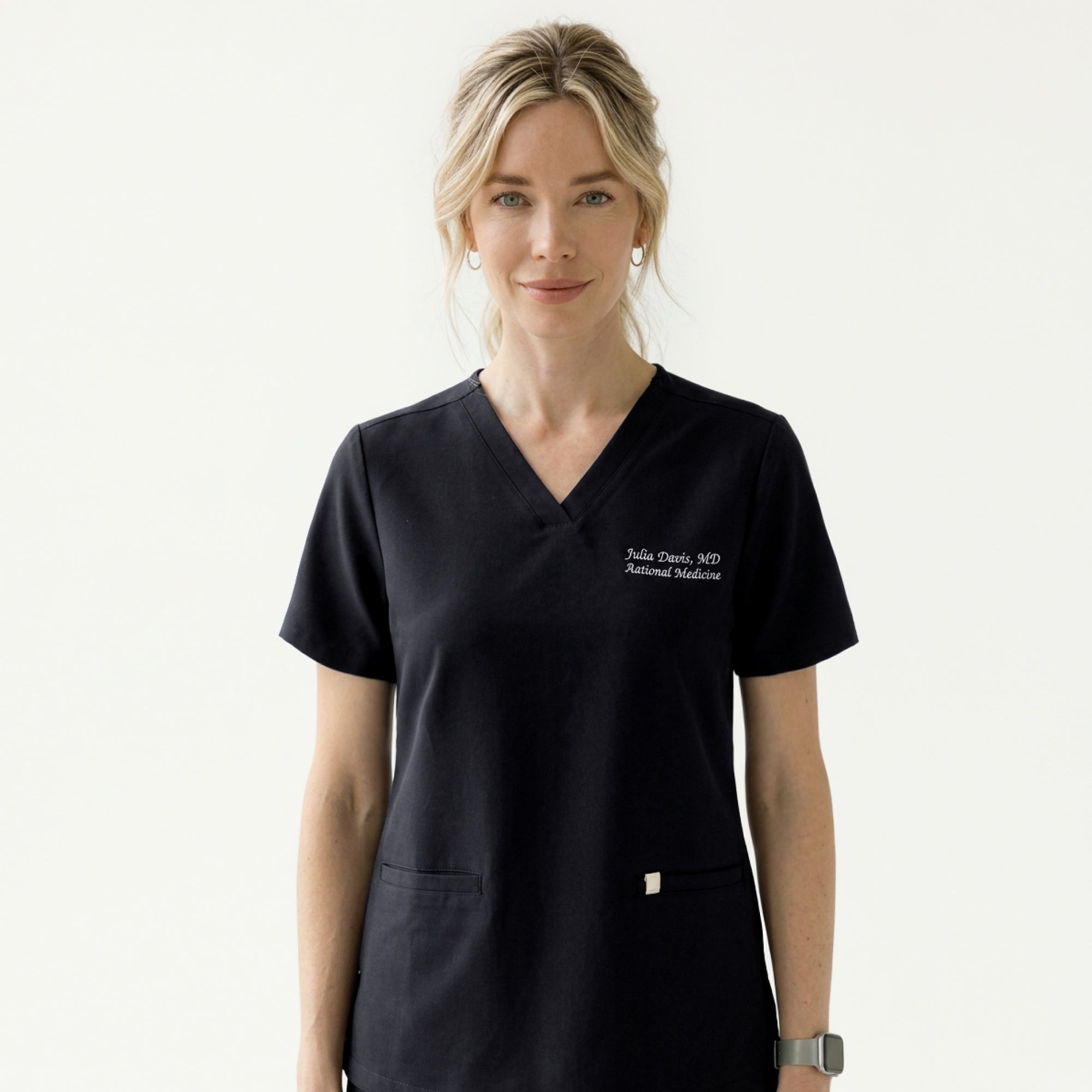 Image of A woman wearing an Eco Black Double Pocket Scrub Top with a V-neck and short sleeves,Eco Black