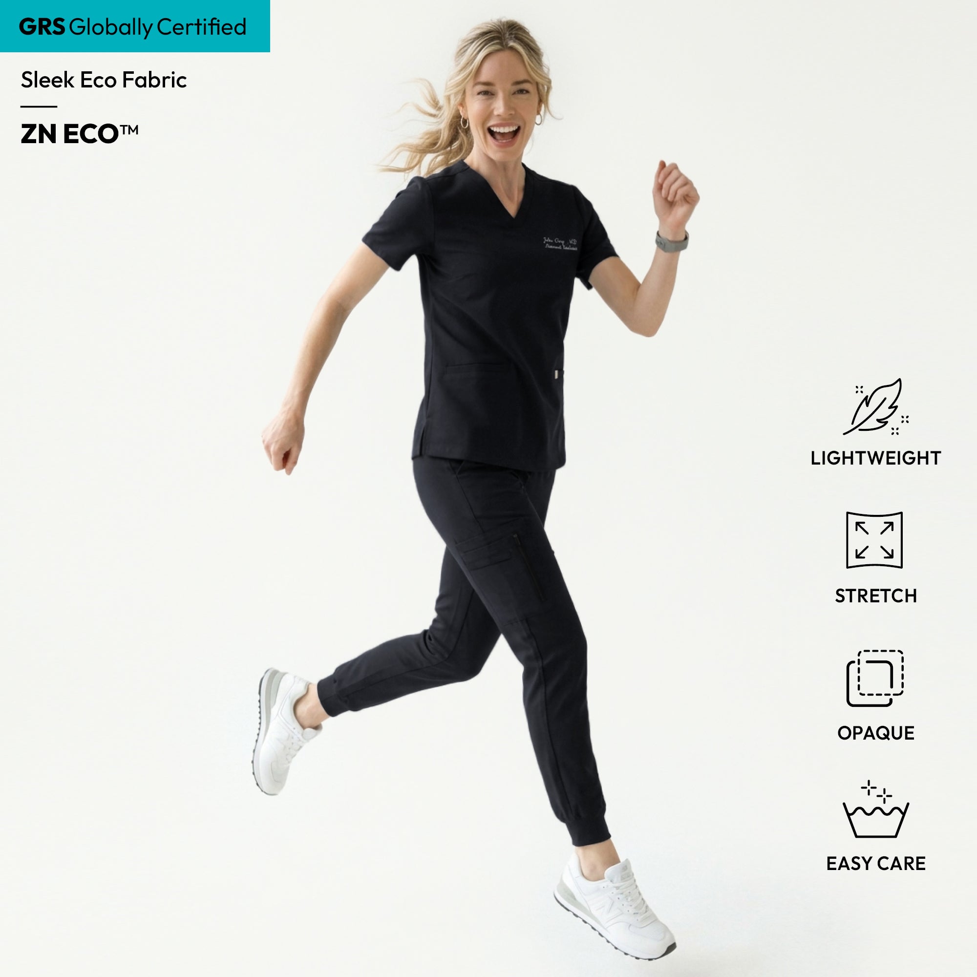Image of Woman wearing a black V-neck scrub top with embroidered name and double front pockets, paired with matching black scrub pants,Eco Black