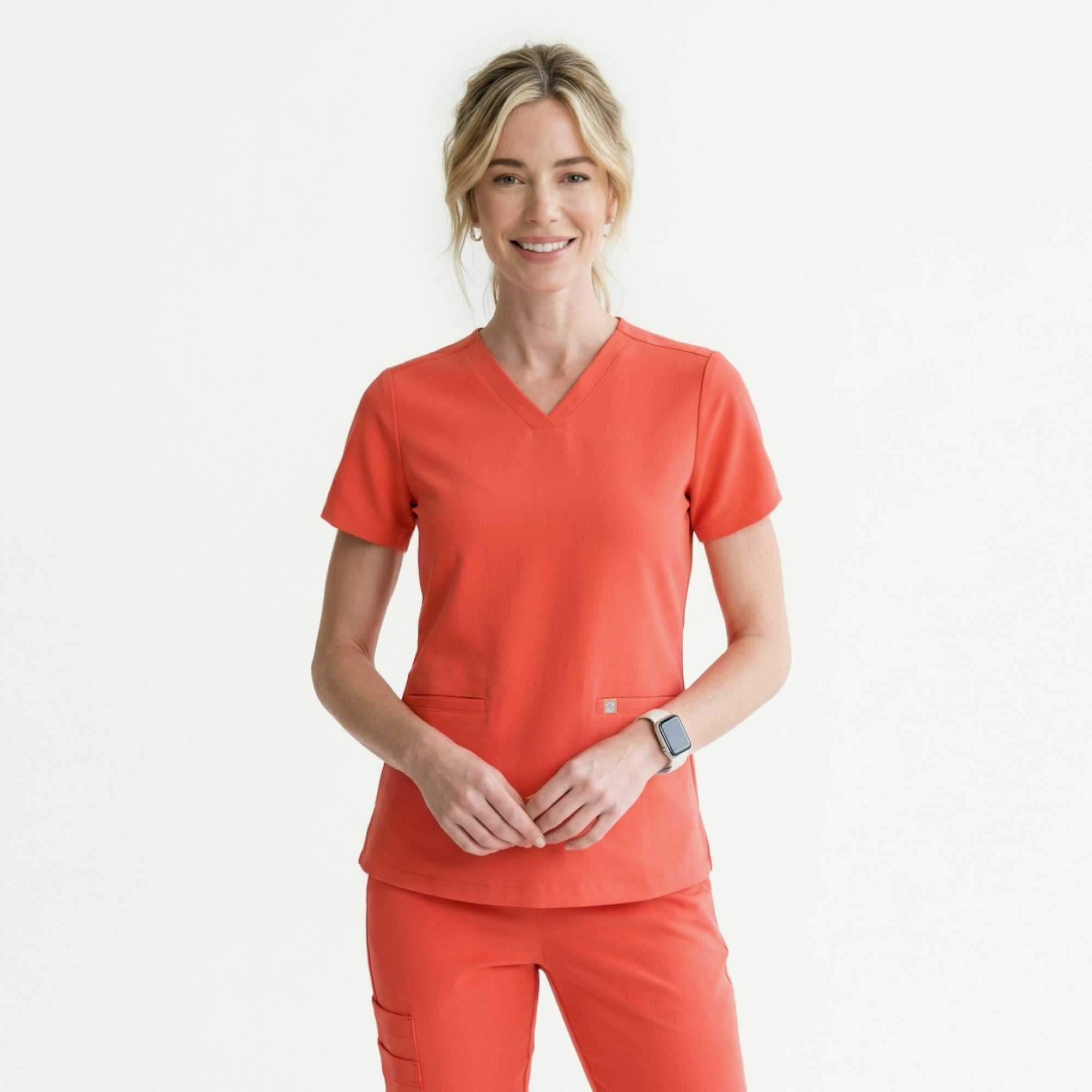 Image of The Tiger Orange Double Pocket Scrub Top features a vibrant orange hue that radiates energy and warmth.