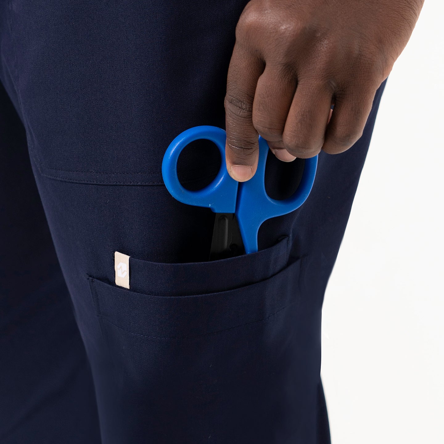 Image of Close-up view of the 8 Pocket Jogger Scrub Pants with blue medical scissors in the side pocket.