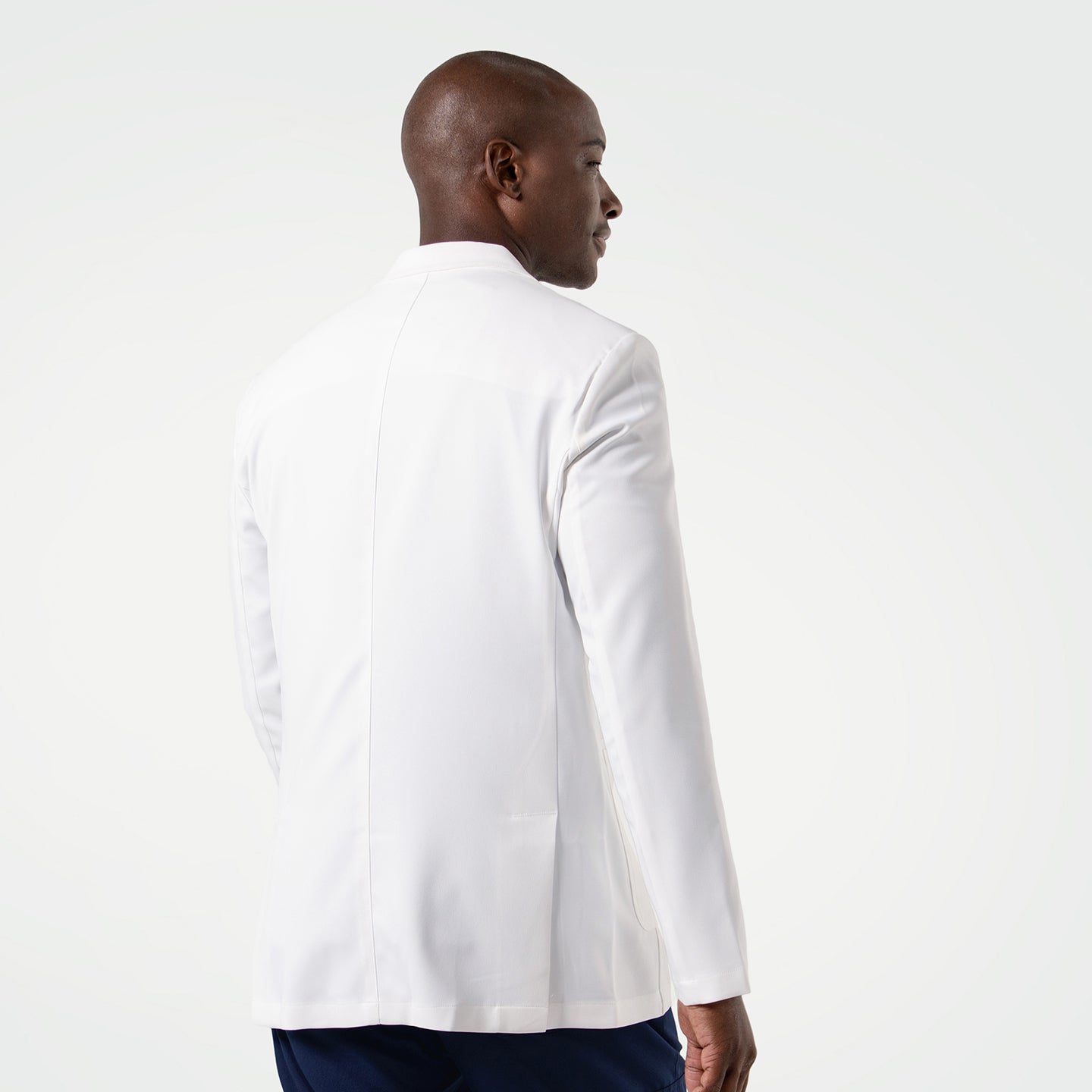 Image of The model is shown from the back, highlighting the clean lines and tailored fit of the men’s LCM-100 lab coat.