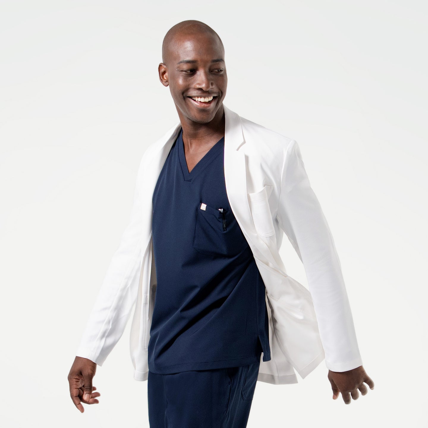 Image of In motion, the model showcases the flexibility and tailored fit of the Men’s LCM-100 Lab Coat.