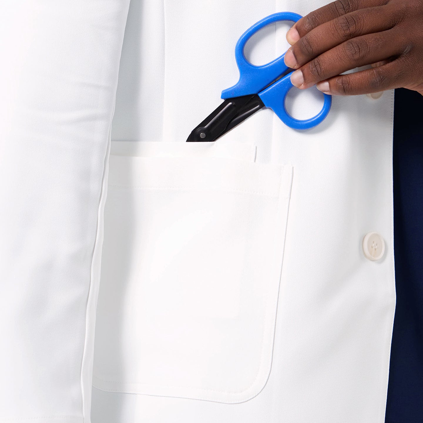 Image of A close-up of the Men’s LCM-100 Lab Coat highlights the functional chest pocket with medical scissors placed inside.
