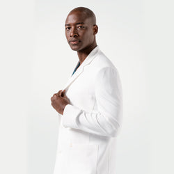 Image of Posing in the Men's LCM-102 Lab Coat in White over medical scrubs, holding the lapel with one hand and looking at the camera, upper body view