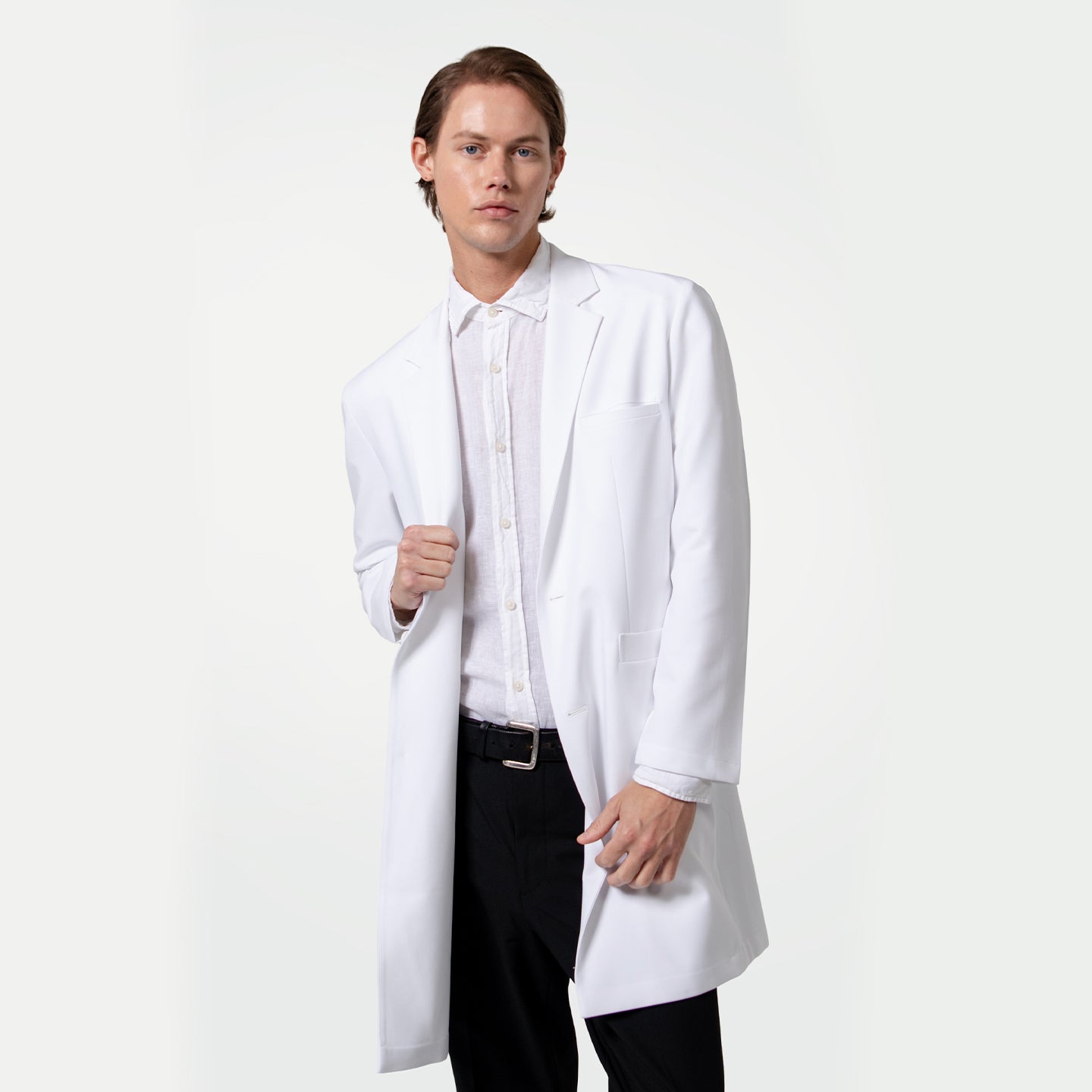 Image of Male doctor wearing a white lab coat over a white dress shirt and black trousers, standing with one hand