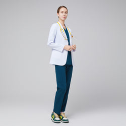 Image of Model facing sideway wearing a white short lab coat, and blue scrub top and bottom under, with yellow stethoscope around her neck and green sneakers,White