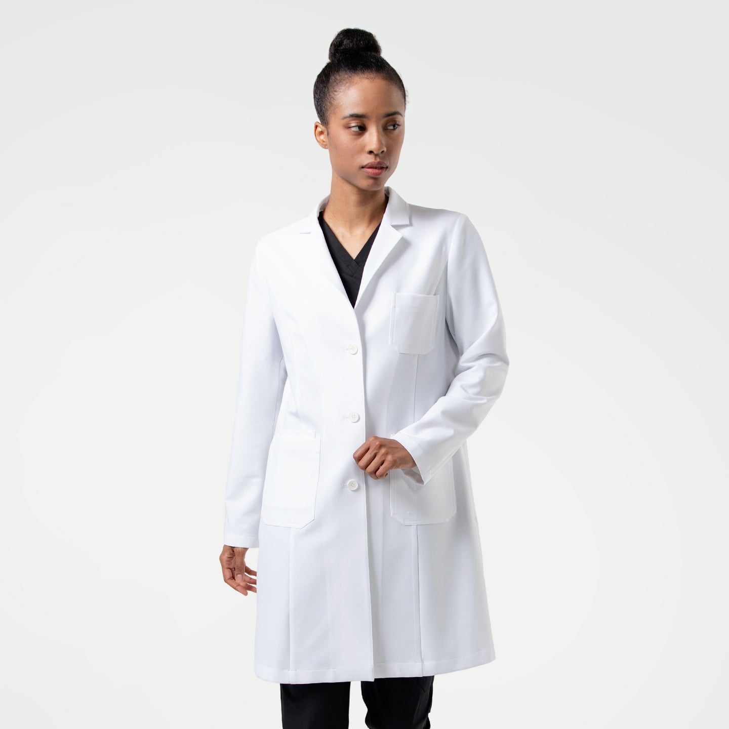 Image of Woman wearing the Women's LCW-102 Lab Coat in White over medical scrubs, standing and looking to the side,White
