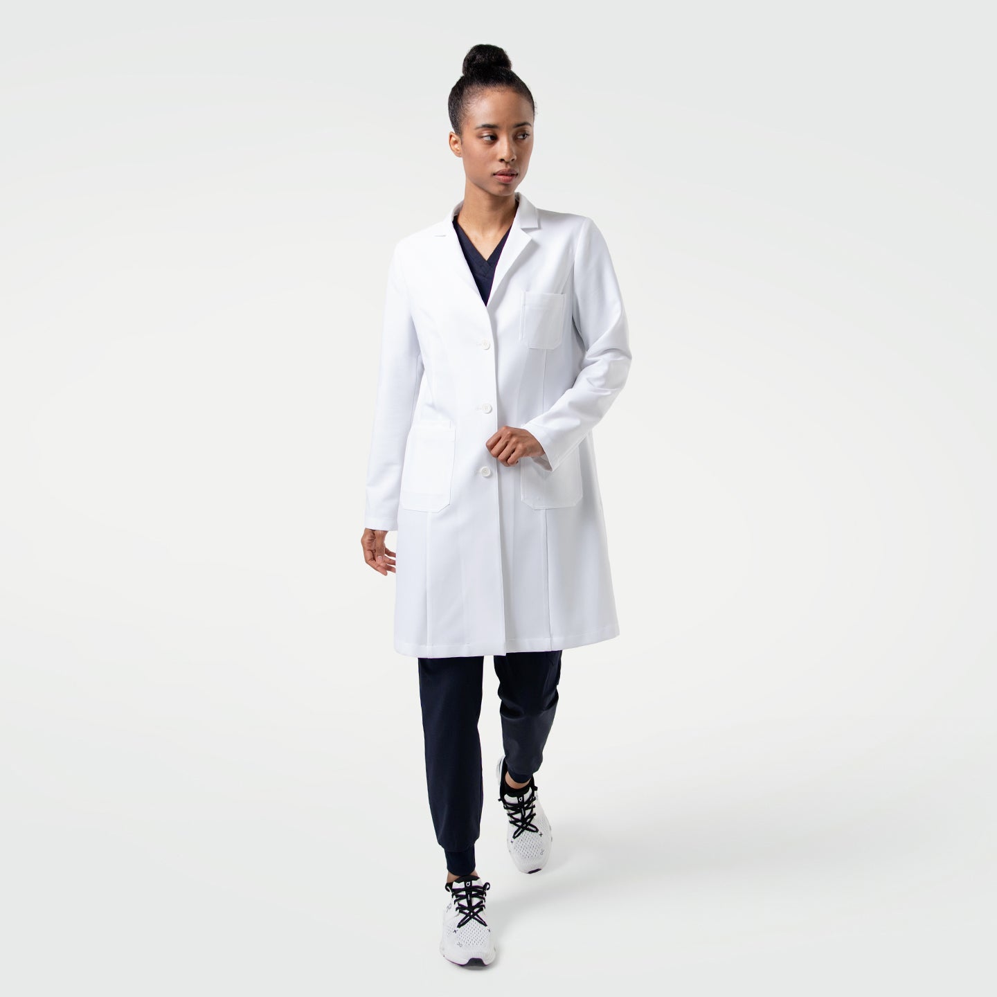 Image of A clean, professional white lab coat featuring a tailored silhouette with a notched lapel, long sleeves, and a straight hem. The coat includes multiple front pockets for essentials and offers a polished, structured look.