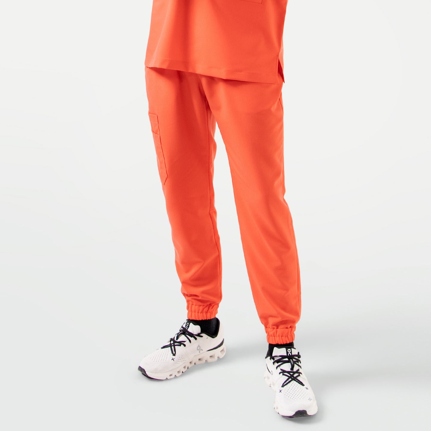 Image of Tiger Orange StretchFit jogger scrub pants in a front view, featuring an elastic waistband, cuffed hems, and a practical side cargo pocket.