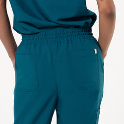 Image of Back view of a person wearing StretchFit Jogger Scrub Pants in Ocean Teal, showing the waistband and two rear pockets.