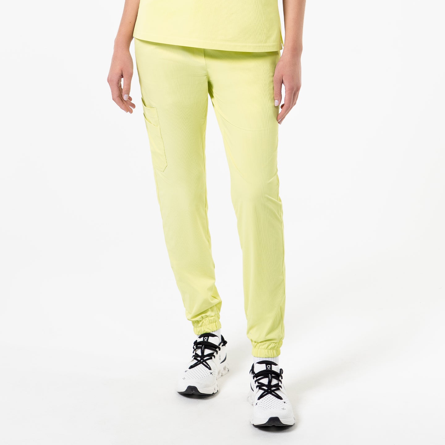 Image of Front view of a person wearing StretchFit Jogger Scrub Pants in Pineapple Yellow, standing with arms relaxed at the sides.