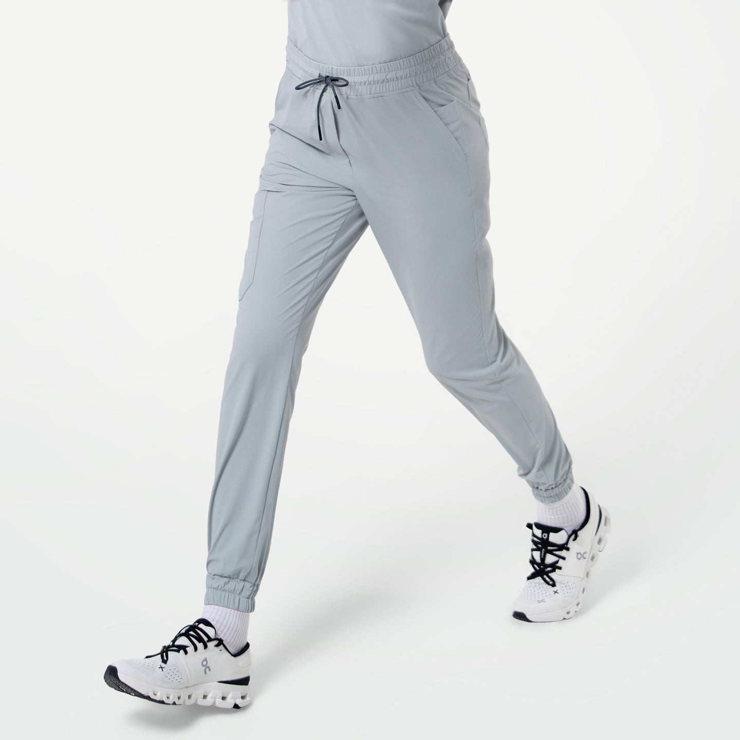 Close-up of a person walking in StretchFit Jogger Scrub Pants in Cool Gray, showing the side pockets and drawstring waistband.