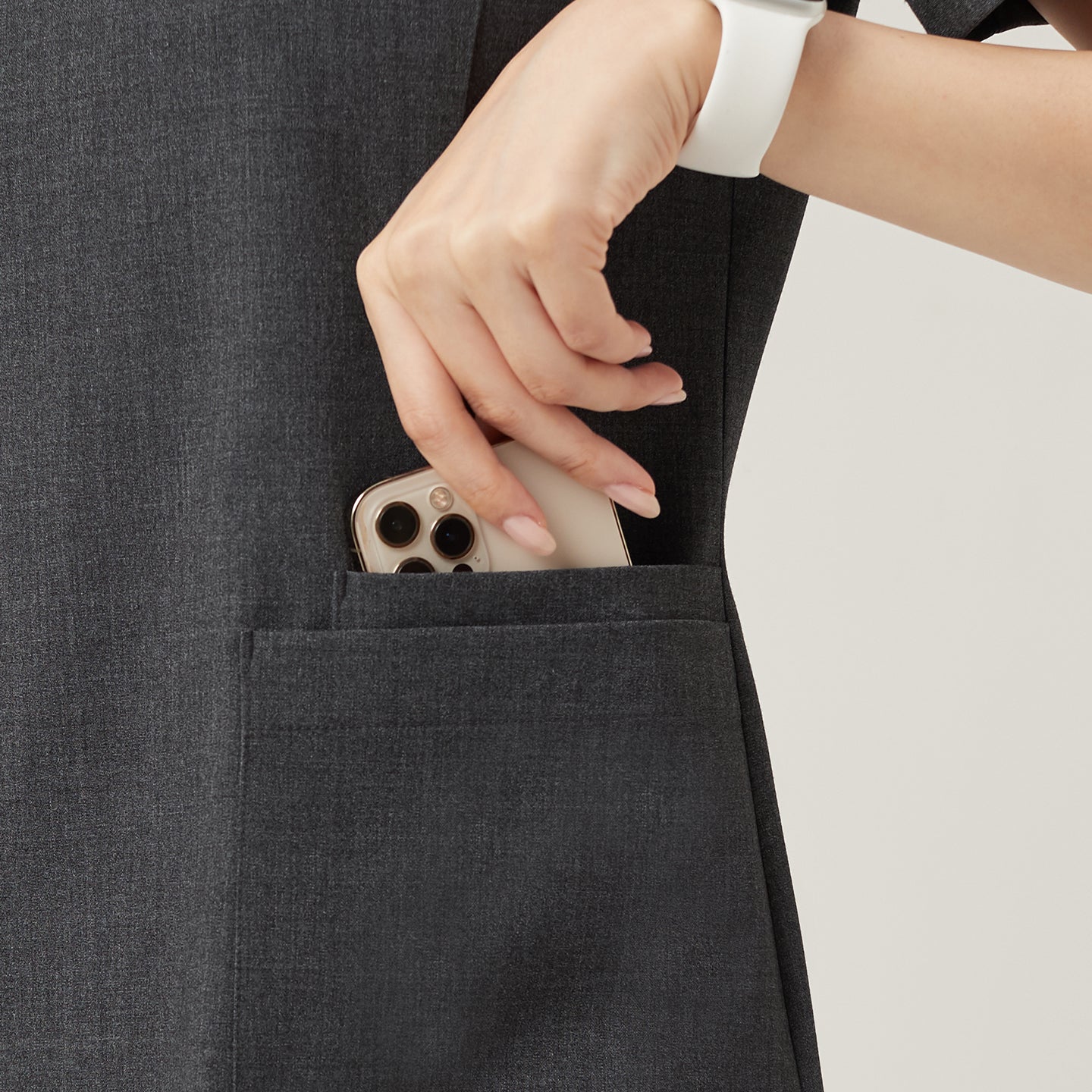 Image of A close-up of the Charcoal Gray OS-228 highlights the practical pocket design, showing a phone being smoothly placed inside for everyday convenience.