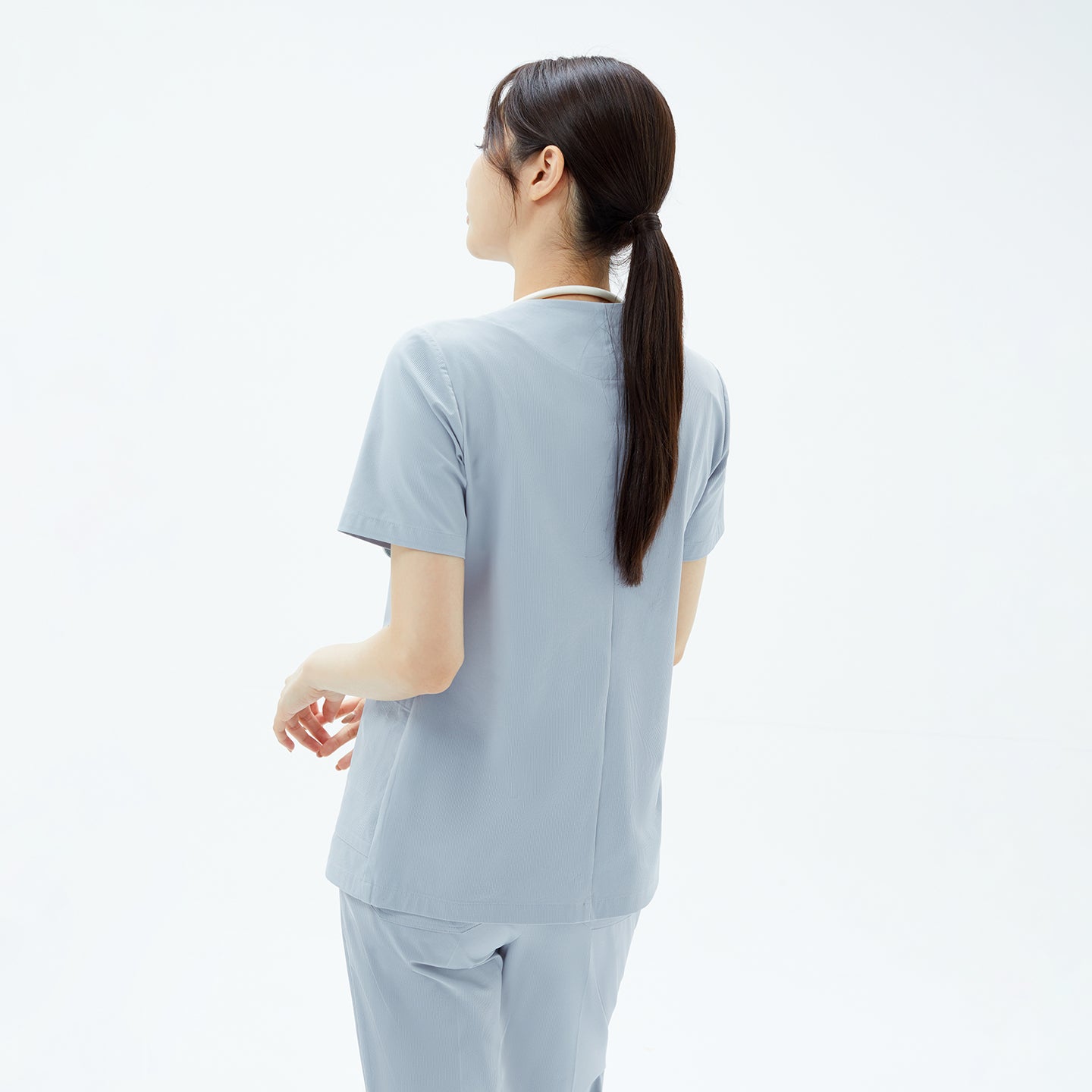 The back view of the Cool Gray OS-224 scrub top highlights its clean seam line and relaxed structure, offering a polished fit with unrestricted movement for all-day comfort.