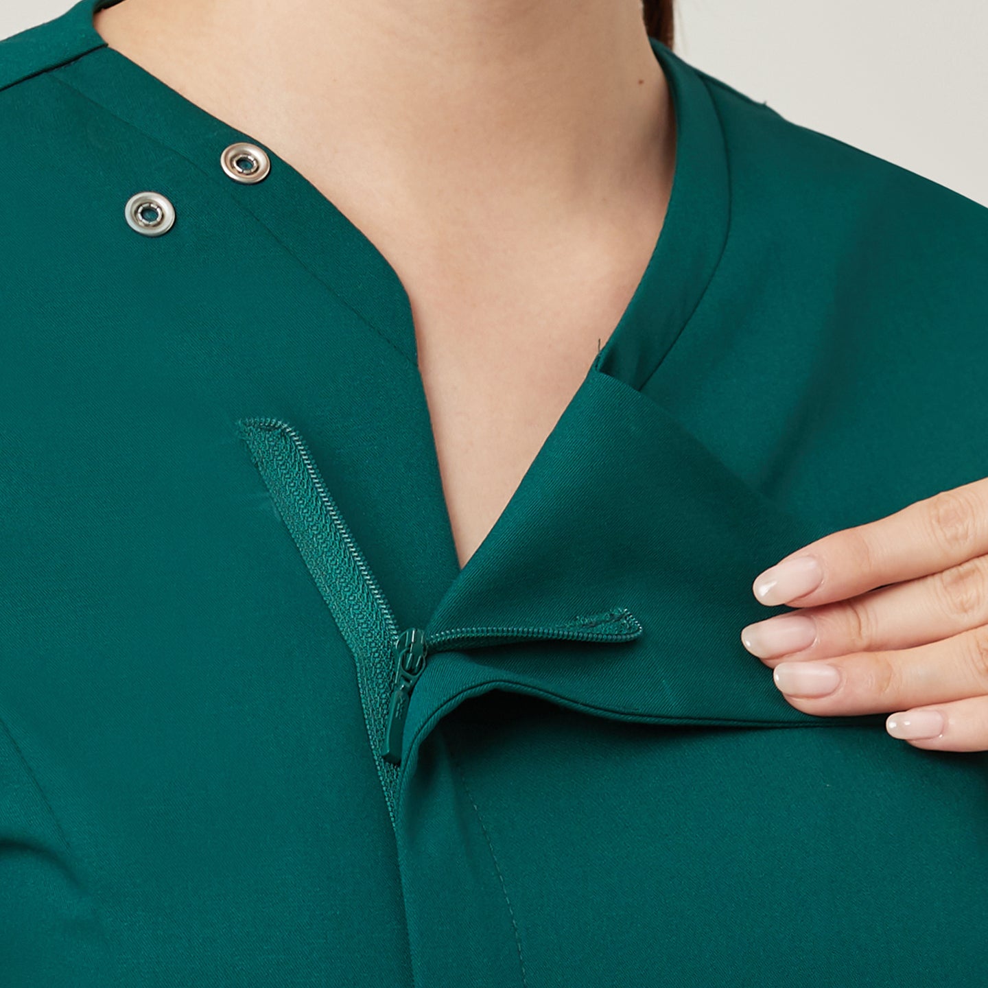 The Pine Green OS-225 features a concealed zipper and snap-button closure for a polished, seamless neckline. This design not only enhances the overall clean aesthetic but also provides convenience and comfort for easy wear throughout the day.