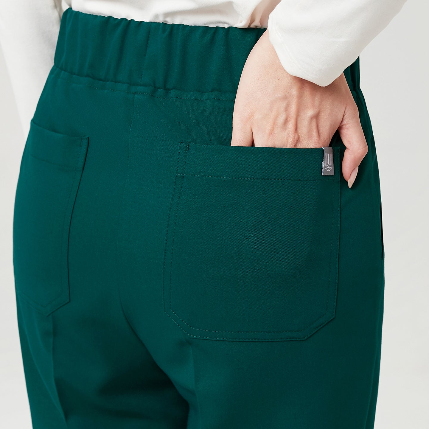 A close-up of the Pine Green Premium Banding Scrub Pants showcasing the neatly stitched back pockets.