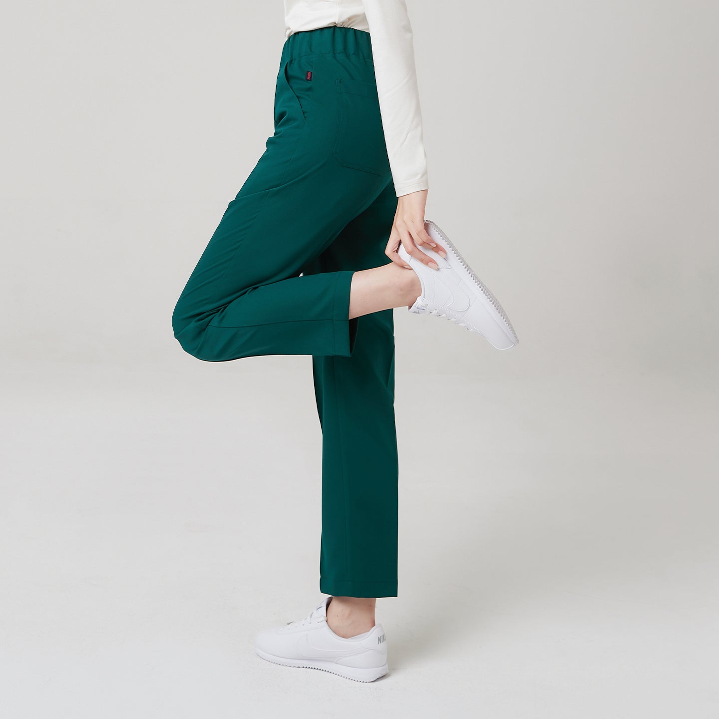 This image highlights the Pine Green Premium Banding Scrub Pants comfortable stretch and flexibility.