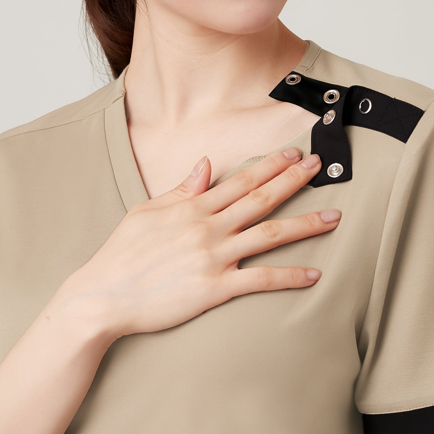 Image of A close-up view highlights the shoulder snap design, allowing for easy wear and removal while adding a subtle accent to the Sand Beige OS-229 scrub.