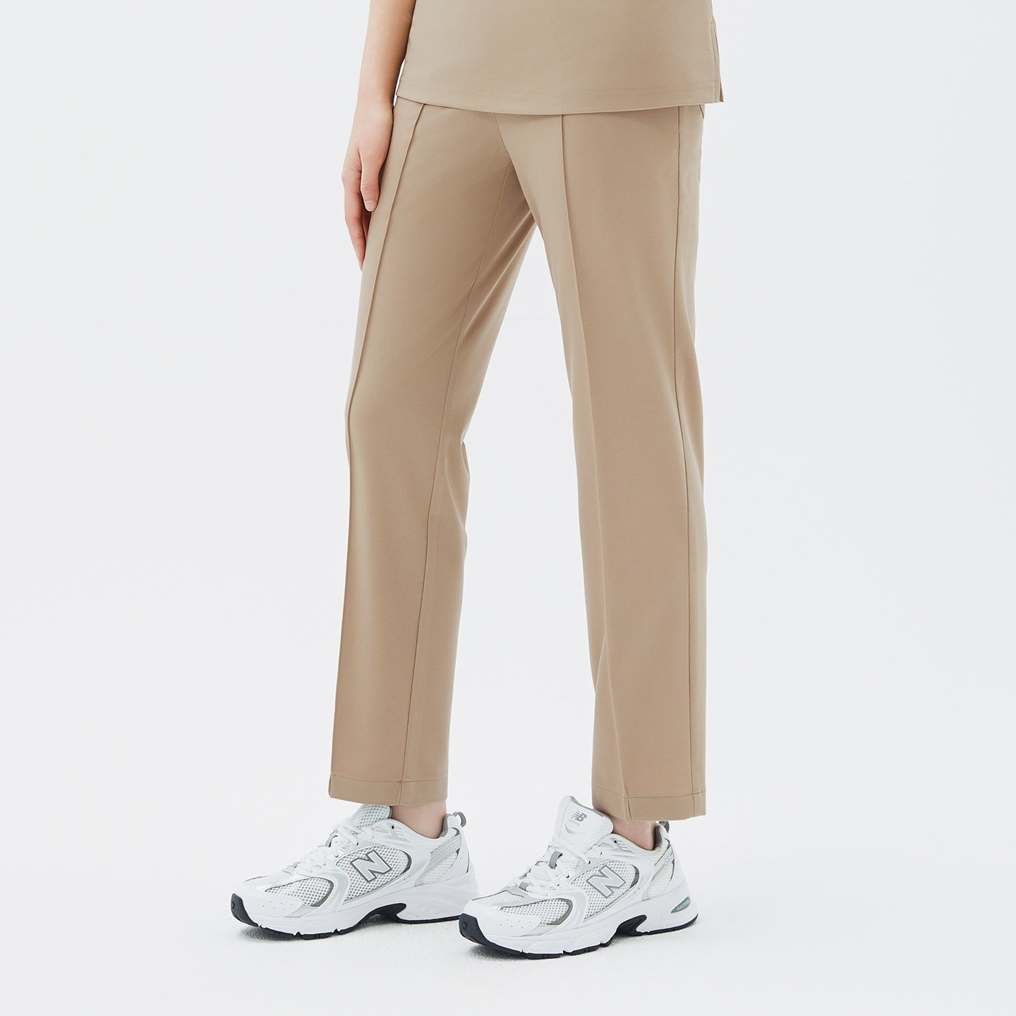 Image of A straight-cut silhouette with refined front creases creates a balanced and elongating look.
The soft beige tone blends elegance with warmth, offering a natural, effortless finish ideal for both movement and style.