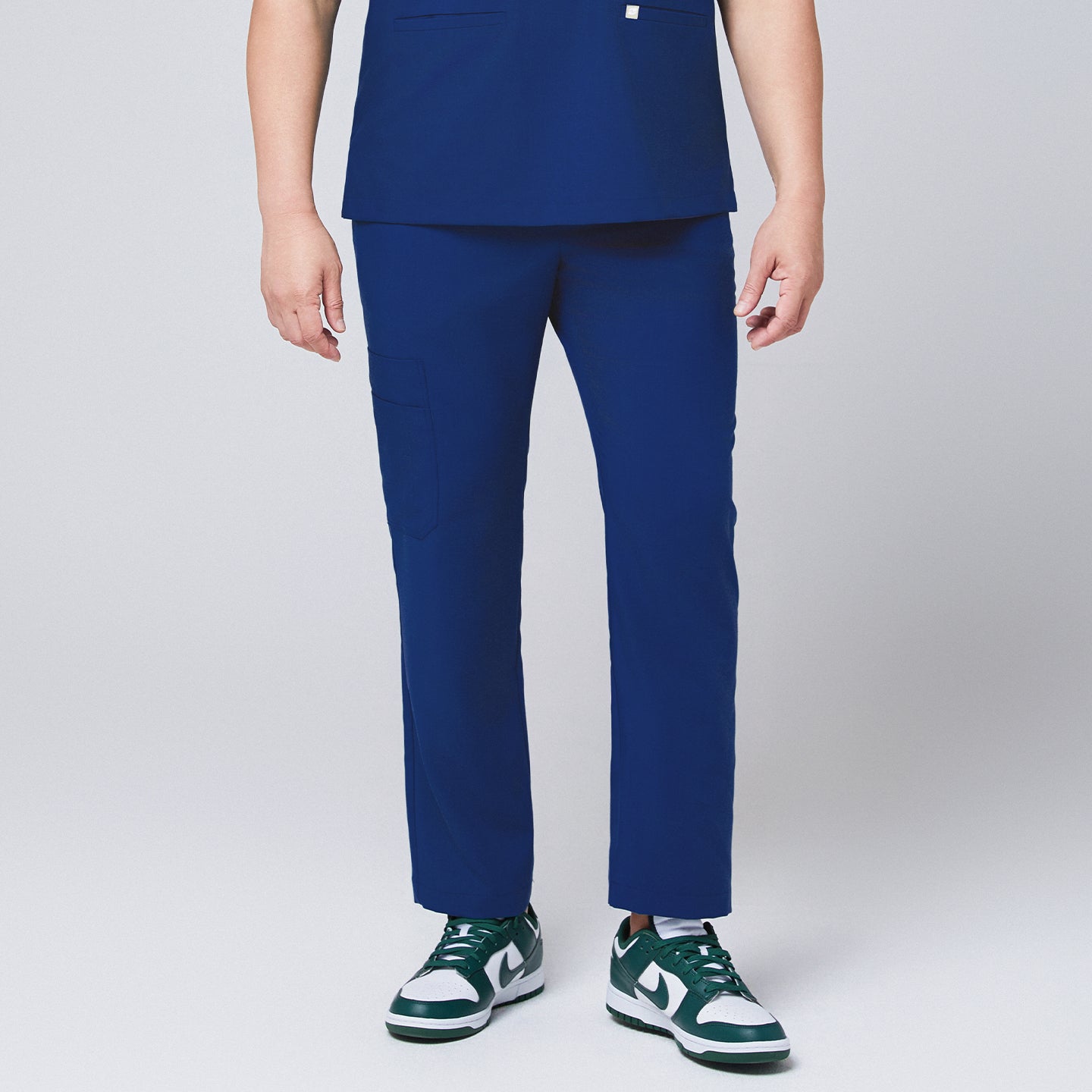 Image of Close-up of Zenir Admiral Blue straight scrub pants with functional side pocket, paired with green sneakers for a professional look,Admiral Blue