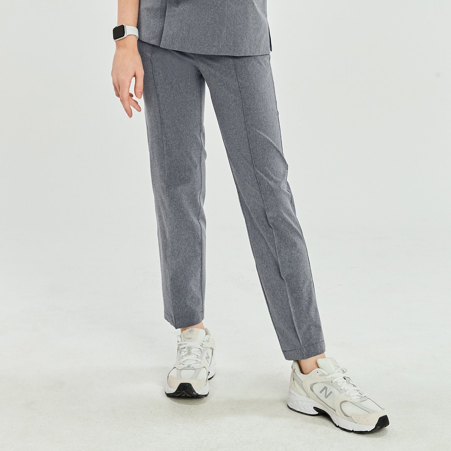 Image of Ash gray scrub pants with straight legs, paired with white sneakers, shown in a casual walking stance,Ash Gray