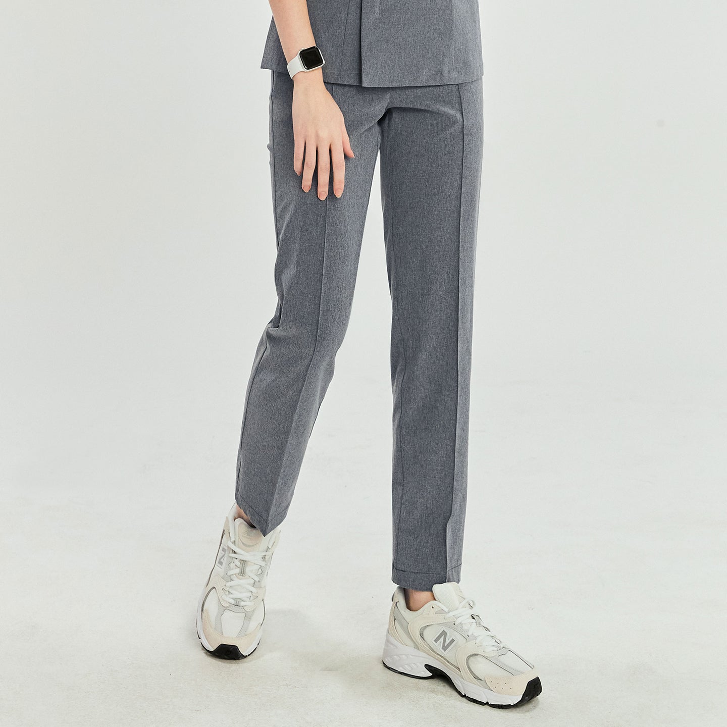 Image of Ash gray scrub pants with straight legs, paired with white sneakers, shown in a walking stance,Ash Gray