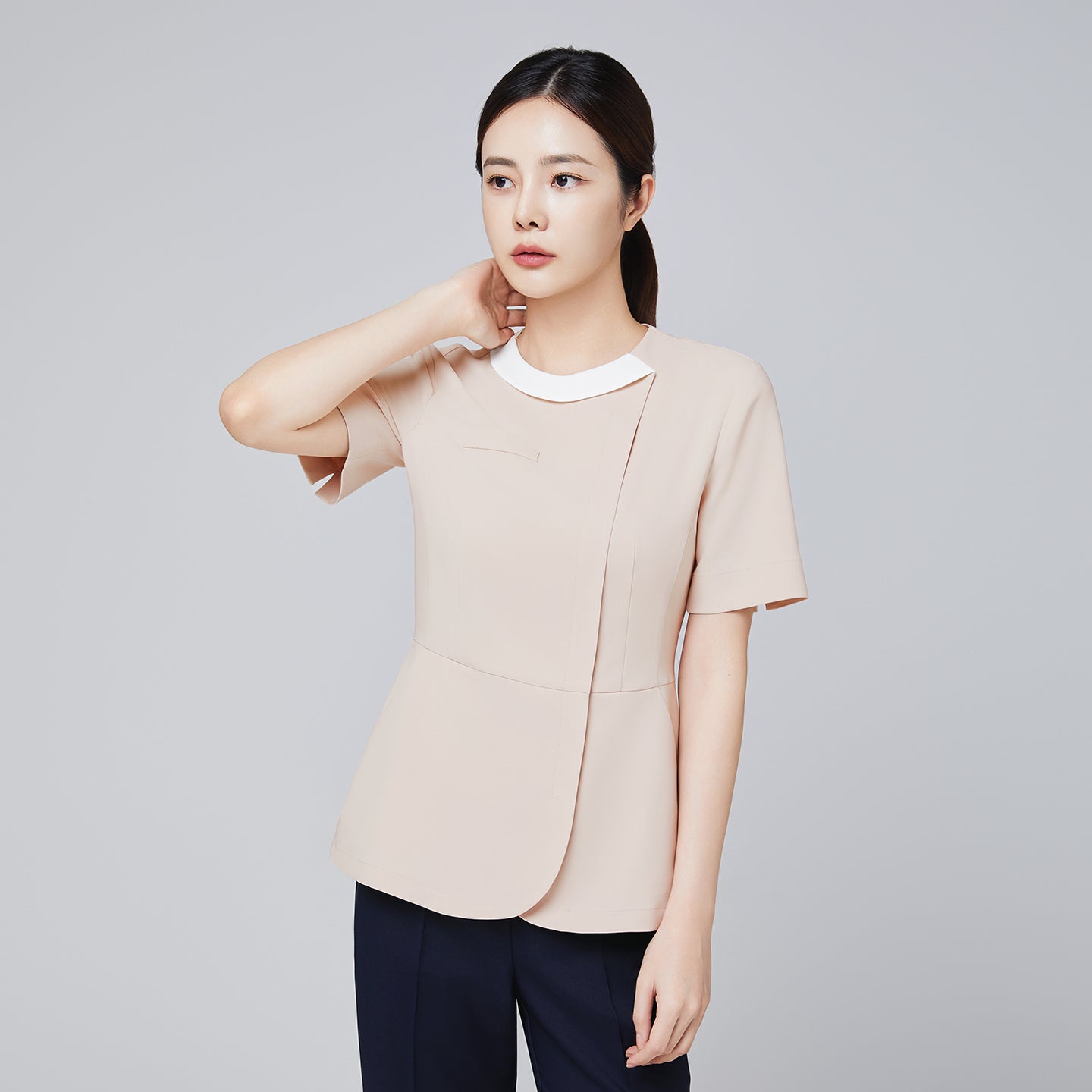 Image of Model wearing TUL NS-149 Beige scrub top with a round white collar, showing a comfortable yet stylish design for healthcare professionals.