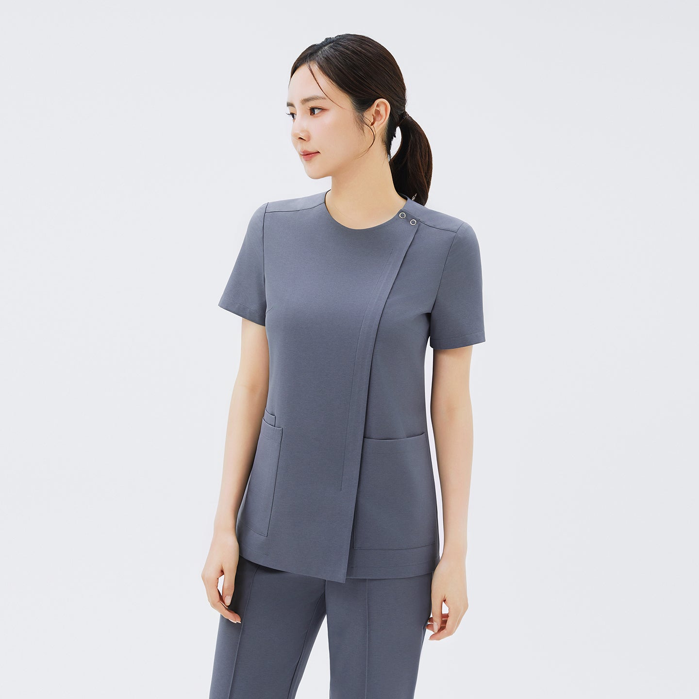 Image of Angled view of TUL OS-212 Women's Dual Snap Front Zipper Scrub Top in Blue Gray, showing dual snap neckline and front zipper detail.