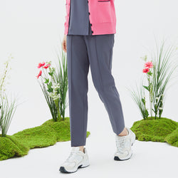 Image of Model wearing TUL Women's Premium Banding Pants in Blue Gray with a pink cardigan, highlighting a modern, comfortable silhouette.