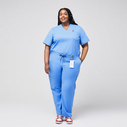 Image of Plus-size model in light blue 3-pocket scrub top with matching pants, badge holder, and red sneakers, ideal for healthcare professionals,Ceil Blue