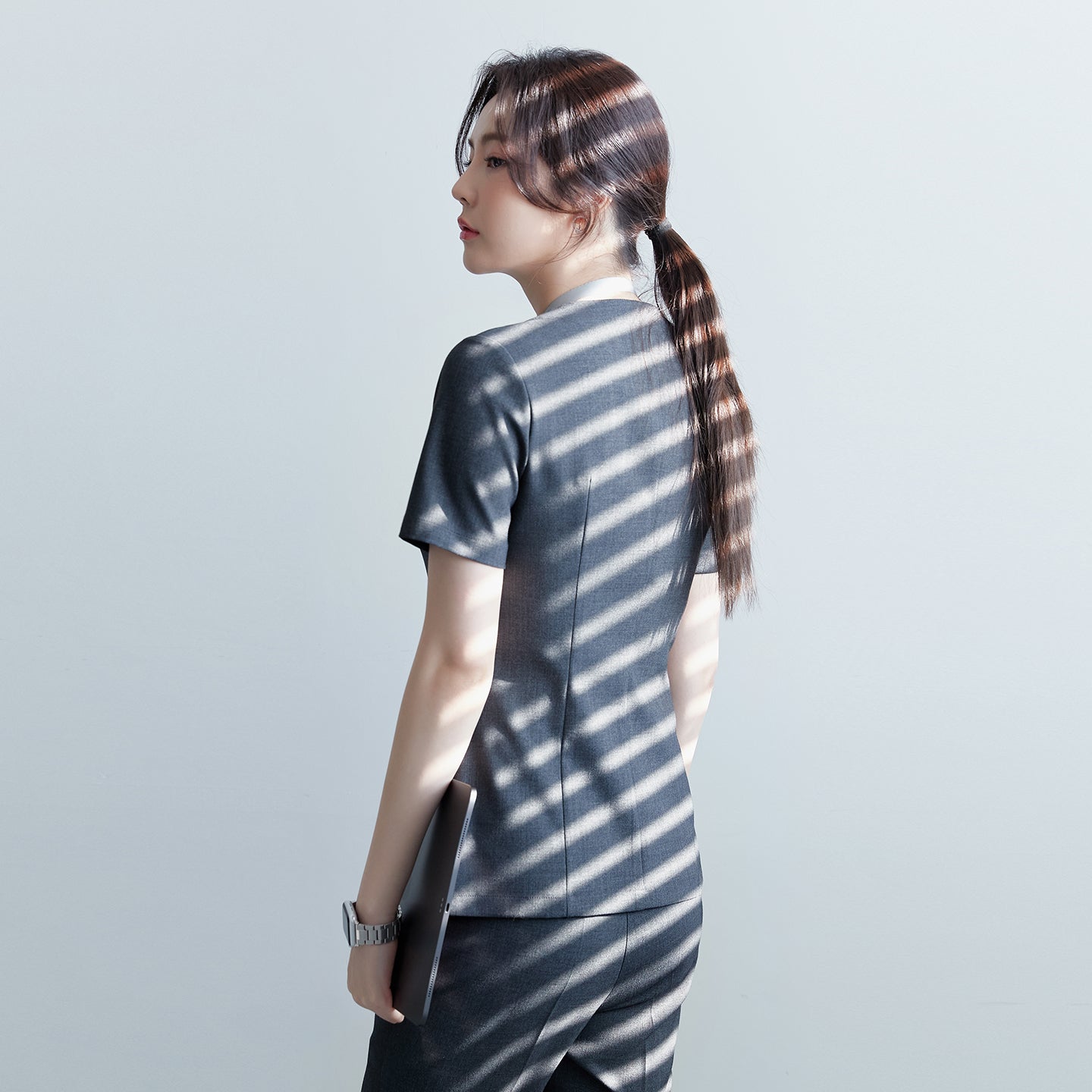 Image of Back view of TUL OS-182 Women's Charcoal Gray scrub top, showing streamlined seams and a tailored silhouette.