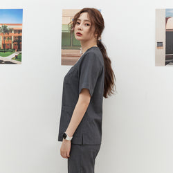 Image of Side view of TUL OS-186 Charcoal Gray scrub top, highlighting a tailored fit and short sleeves.