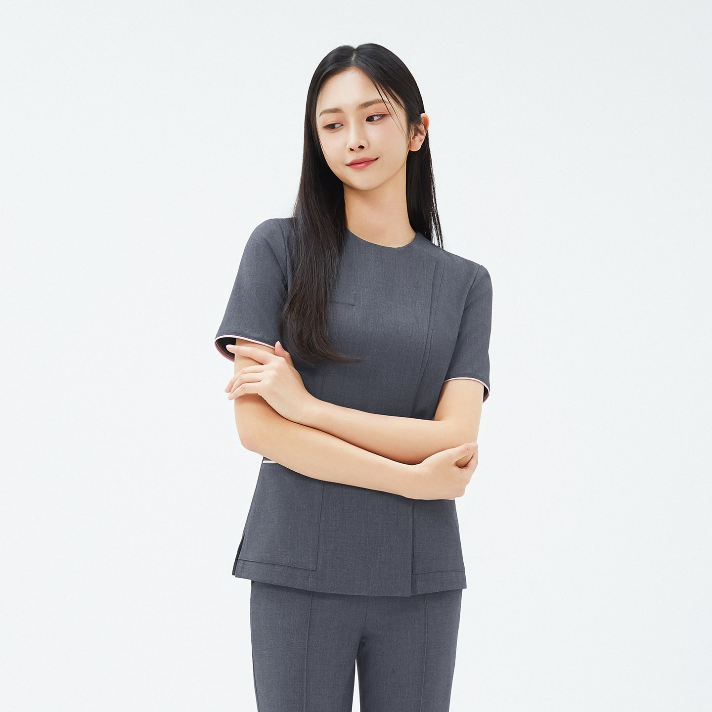 Model wearing TUL OS-211 Chacoal Gray scrub top, featuring short sleeves and subtle edge stripe details for a modern look.