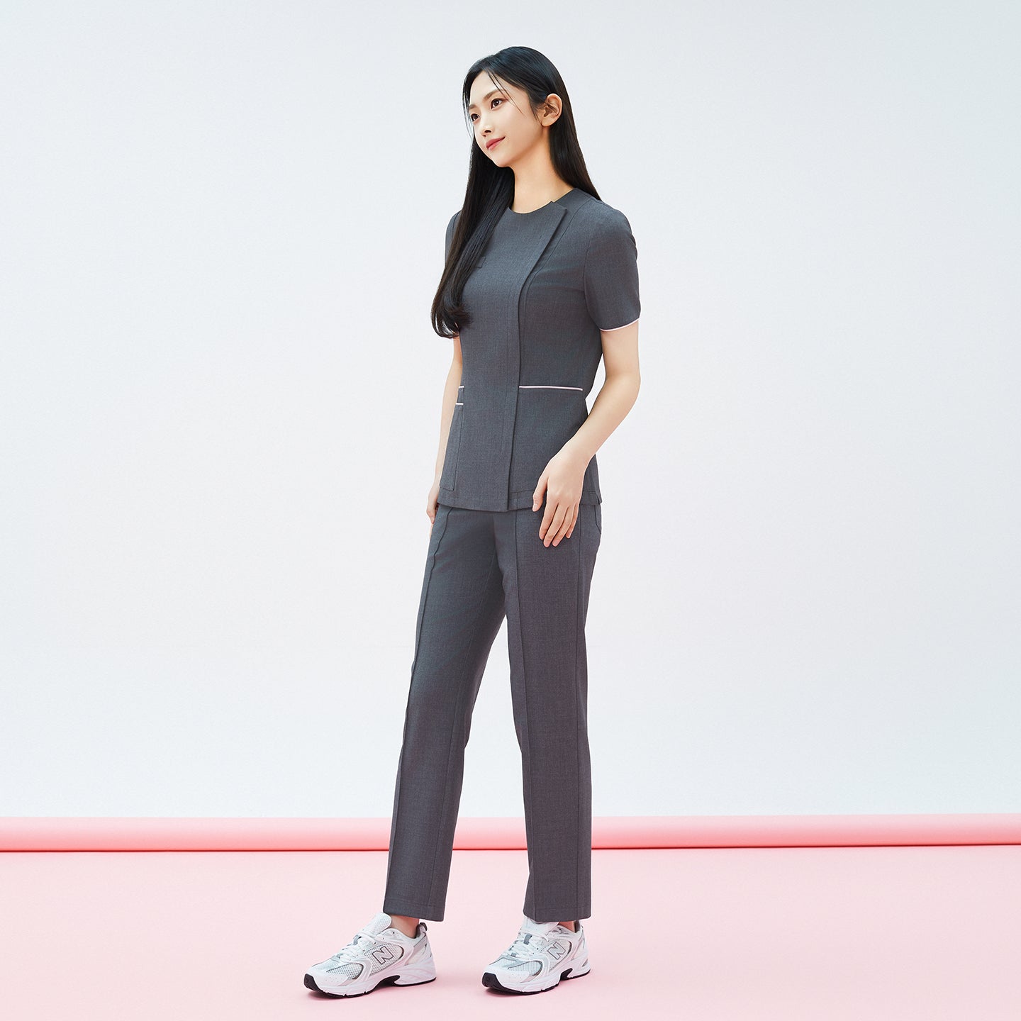 Full-length side view of TUL OS-211 Women's Edge Stripe Scrub Top in Chacoal Gray, highlighting the contrast piping at the waist.