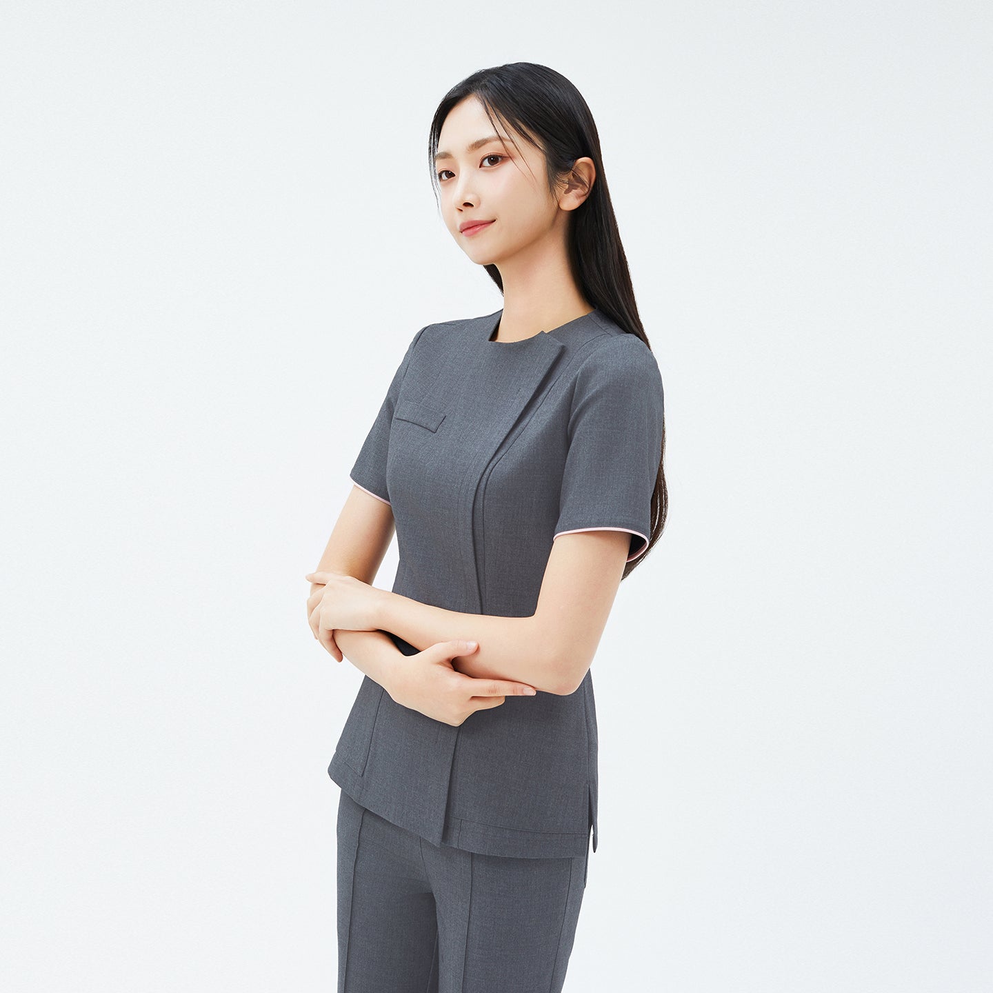 Angled shot of TUL OS-211 Chacoal Gray scrub top, showing streamlined seams and contrast piping on the sleeves.