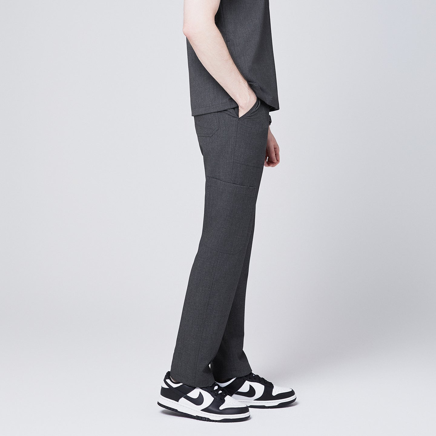 Close-up side view of Zenir charcoal-gray zipper straight scrub pants, worn with black-and-white sneakers, showcasing pocket and stitching details,Charcoal Gray