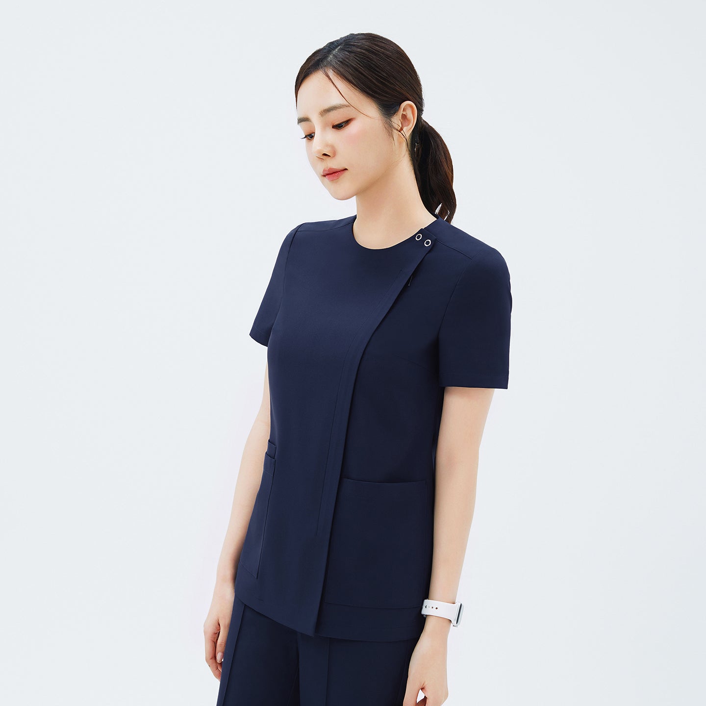 Image of Side angle of TUL OS-213 Classic Navy scrub top, highlighting the discreet front zipper closure and short sleeves.