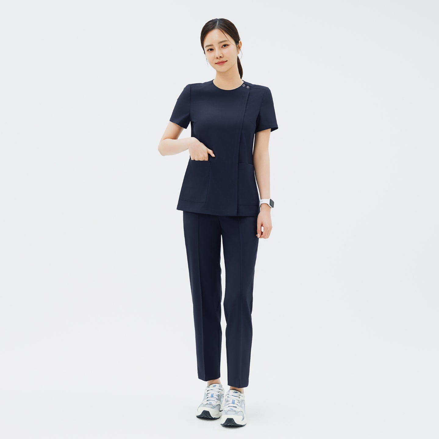 Image of Model wearing TUL Women's Premium Banding Pants in Classic Navy with a coordinating scrub top, showcasing a polished, uniform look.