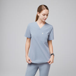 Image of Female healthcare professional wearing a cool gray scrub set with a single pocket, standing in a relaxed pose,Cool Gray