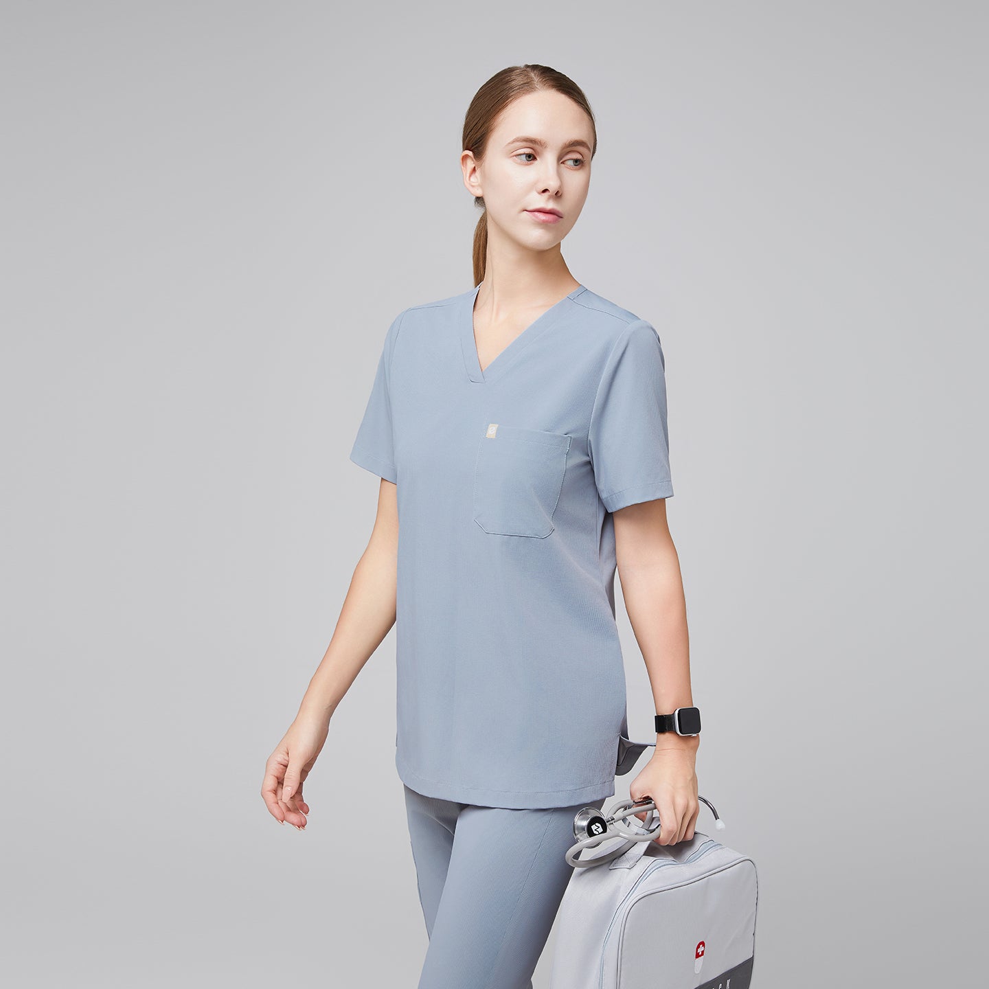 Image of Cool gray single-pocket scrub top Zenir, model wearing close-up with V-neck and chest pocket detail.