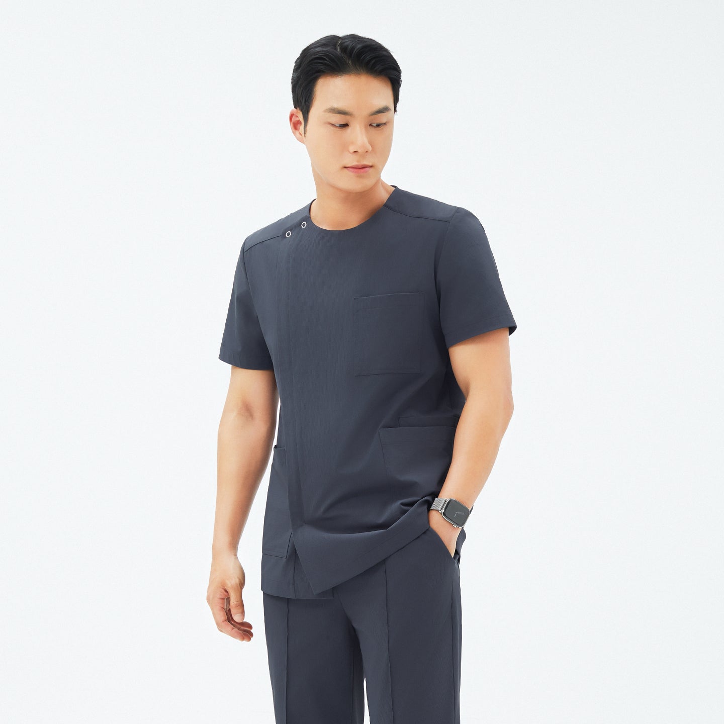 Image of Model wearing TUL DS-189 Men's Round Snap Zipper Scrub Top in Deep Gray, showcasing a tailored fit and convenient snap closures near the shoulder.