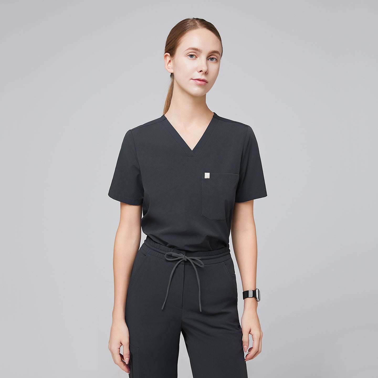 Image of Deep gray single-pocket V-neck scrub top paired with drawstring pants, offering a clean and professional medical uniform style,Deep Gray
